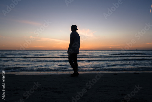 person walking on the beach at sunset