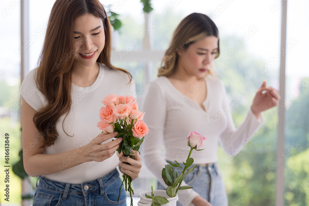 The two Asian woman florist working flower arrangement of colorful of rose to making of bouquet in flower shop.