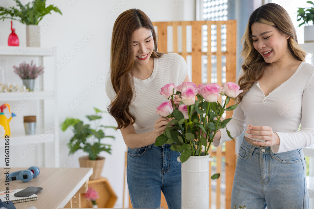 The two Asian woman florist working flower arrangement of colorful of rose to making of bouquet in flower shop. The two Asian woman florist working flower arrangement of colorful of rose to making of bouquet in flower shop.