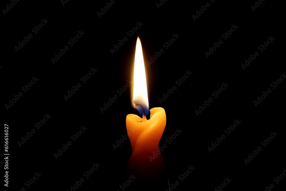 Brennende Kerze, leuchtende Flamme in Gelb und Orange Brennende Kerze, leuchtende Flamme in Gelb und Orange