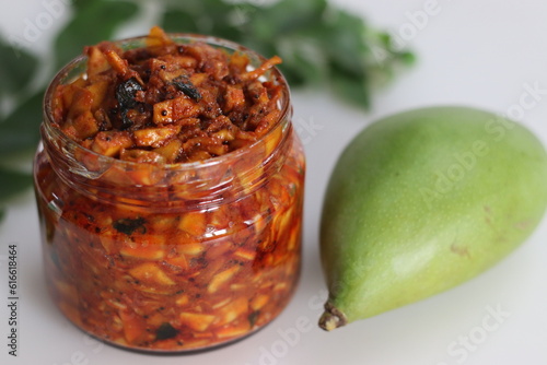Kadumanga achar. Kerala style instant mango pickle made of chopped unripe raw totapuri mangoes, with mustard leaves, curry leaves and spices. photo