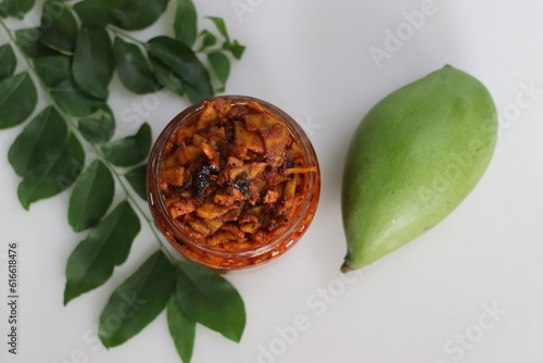 Kadumanga achar. Kerala style instant mango pickle made of chopped unripe raw totapuri mangoes, with mustard leaves, curry leaves and spices. photo