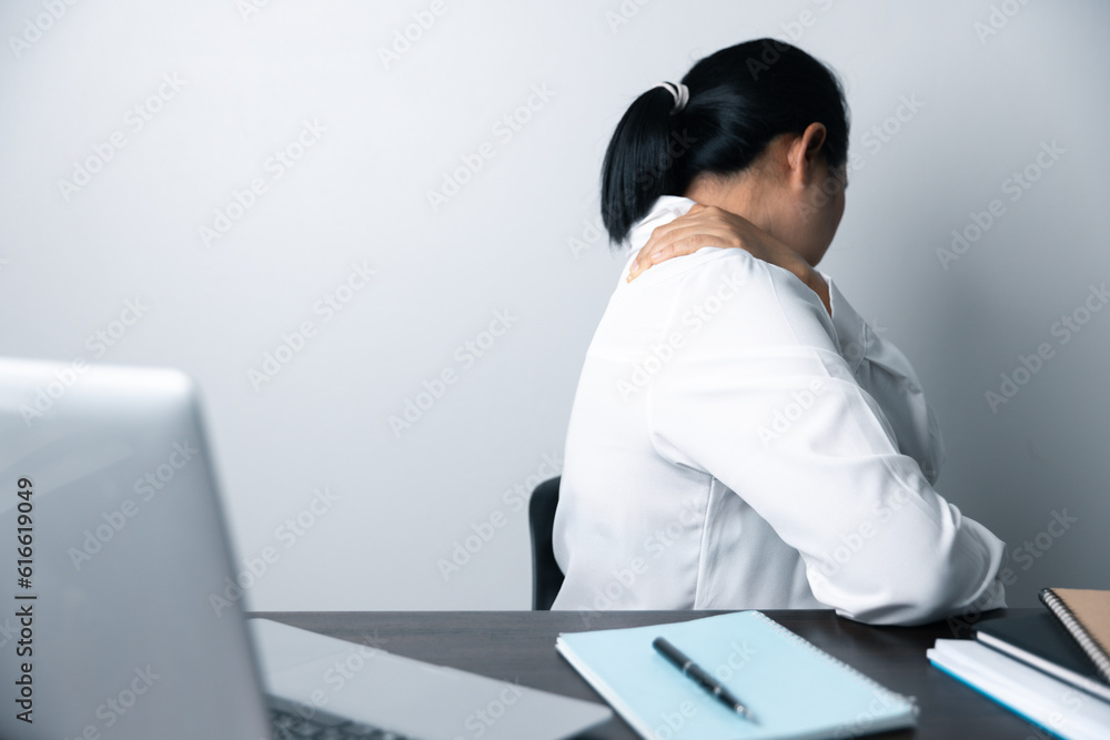 A business office worker is an asian woman is sitting in front of the laptop computer. A businesswoman stressing her body part fingers, hands arm. A femaleOffice manager is exhausted at her workplace. A business office worker is an asian woman is sitting in front of the laptop computer. A businesswoman stressing her body part fingers, hands arm. A femaleOffice manager is exhausted at her workplace.