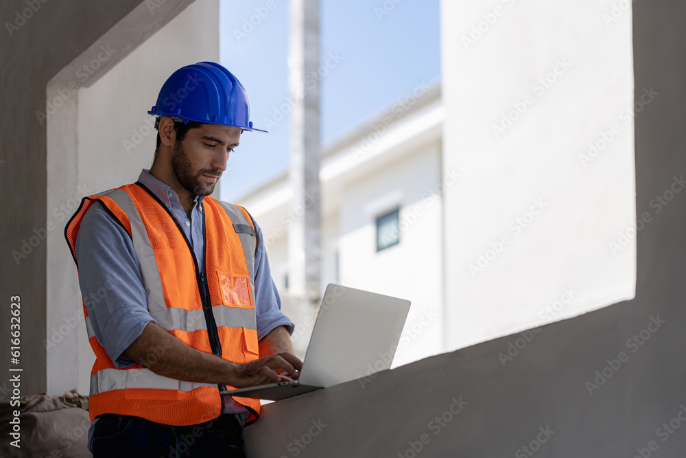 An engineer in a hardhat is using a tablet computer in a heavy industry site. An engineer in a hardhat is using a tablet computer in a heavy industry site.
