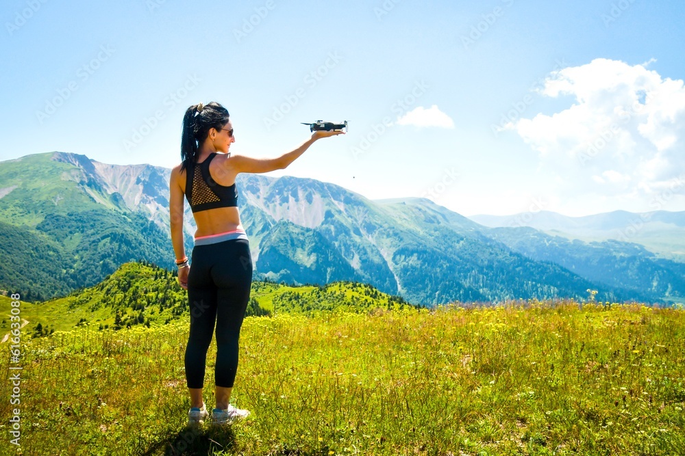 Aerial close up view pretty caucasian woman hold drone in hand for take off in scenic mountains location. Aerial cinematography and travel with quadcopter Aerial close up view pretty caucasian woman hold drone in hand for take off in scenic mountains location. Aerial cinematography and travel with quadcopter