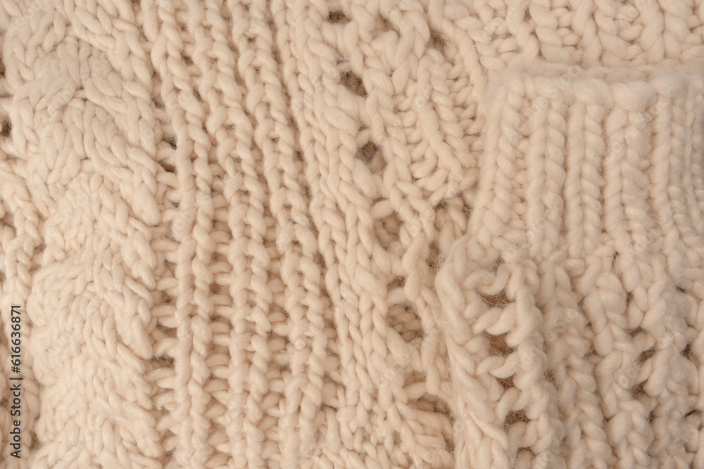 A fragment of beige knitted fabric, knitted from white sheep wool. A fragment of beige knitted fabric, knitted from white sheep wool.