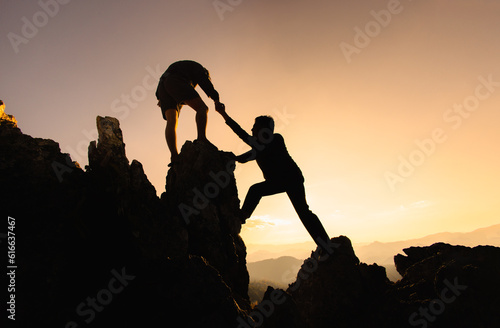 Concept of business, Hikers climbing up mountain cliff and one of them giving helping hand. People helping and, team work concept.