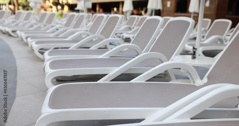Row of stylish comfortable sun loungers pool. Quality lounge chairs for a hotel or spa center Row of stylish comfortable sun loungers pool. Quality lounge chairs for a hotel or spa center