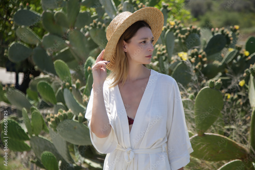 Fashion portrait of tourist woman in white linen outfit during summer vacation in small Mediterranean village