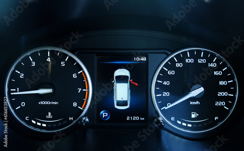 A low light picture with noise effect of car dashboard meter with door open indicator.