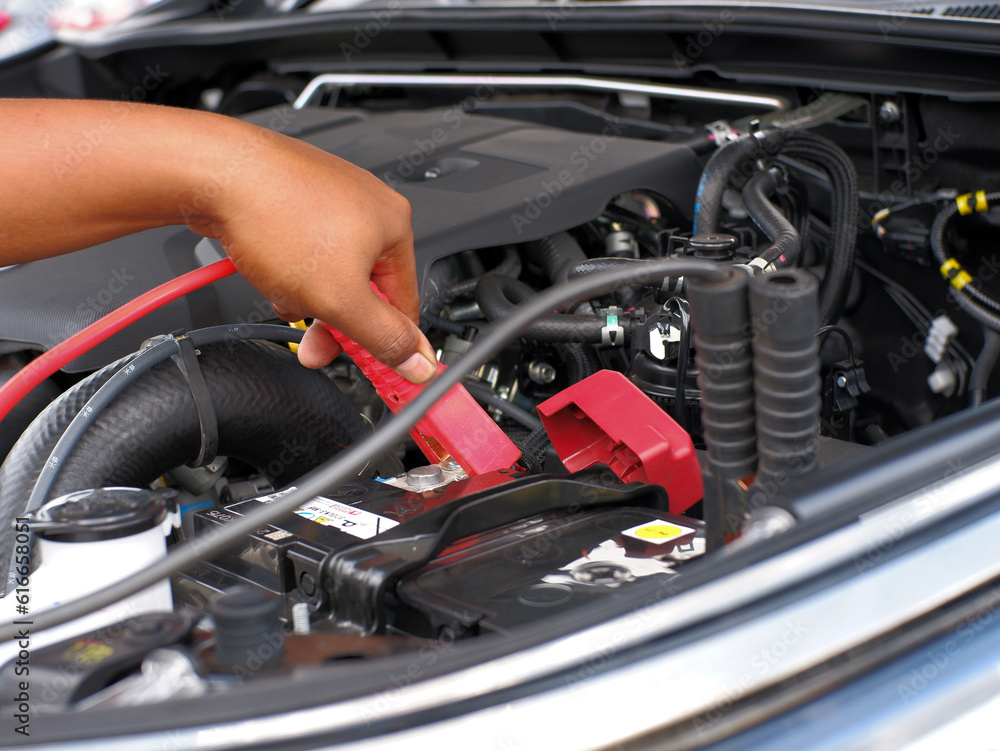 man charging car battery using jumper cables man charging car battery using jumper cables