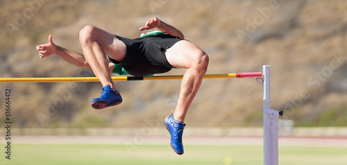 High jump athletics, high jump male athlete successful attempt over bar