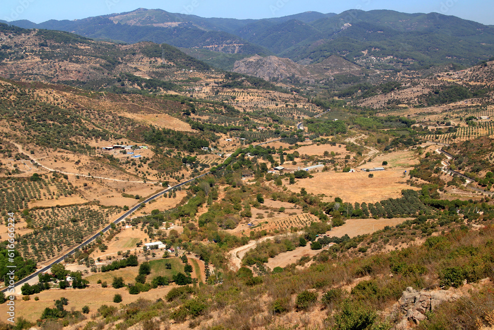 A landscape with a mountain view and a winding road against a blue sky in the city of Bergama, near Izmir, Turkey
