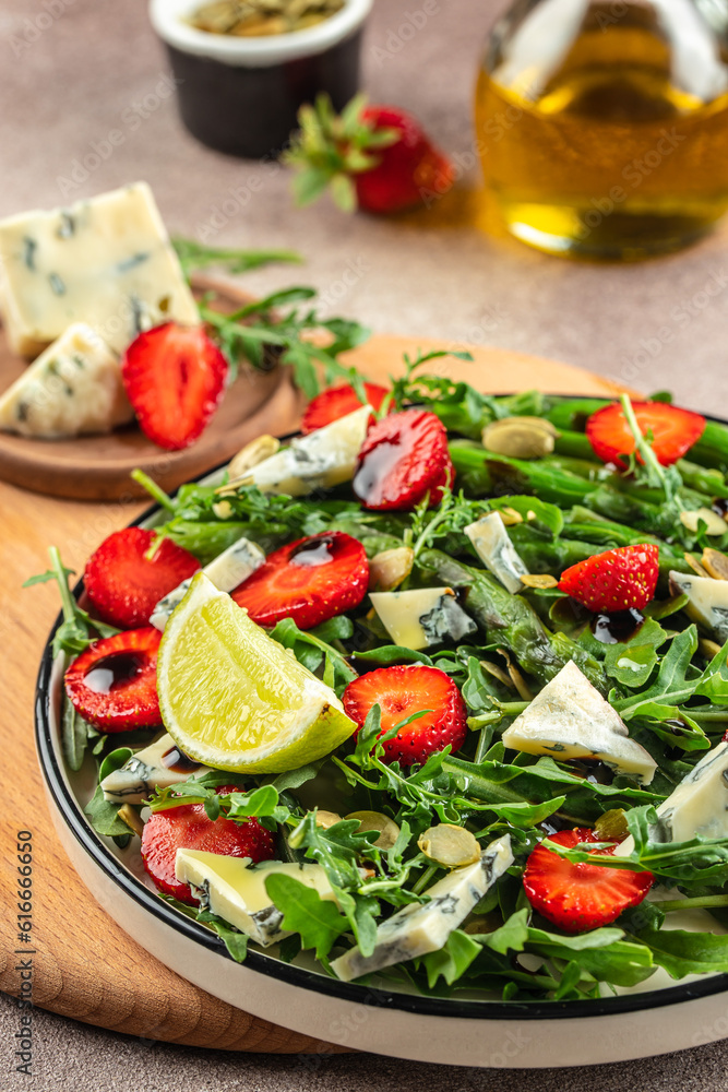 strawberry salad with asparagus, arugula, blue cheese and seeds. Delicious breakfast or snack, Clean eating, dieting, vegan food concept. top view