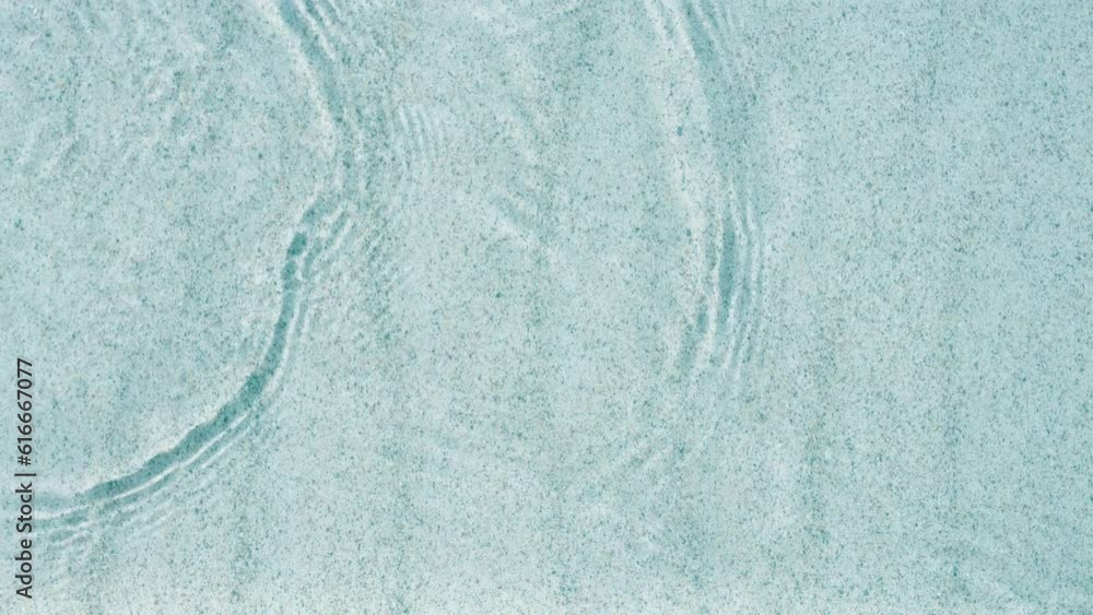 abstract white sand beach with transparent water wave from above, calm rippled water surface background concept with space for text or product presentation