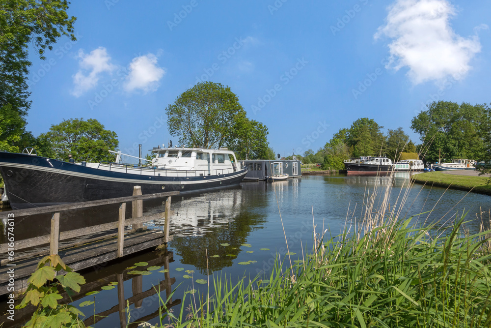 Schiffe ankern in einem Kanal, Friesland, Niederlande