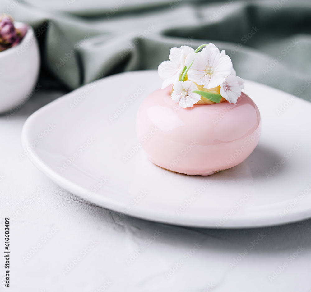 Pink mousse cake decorated with white flowers