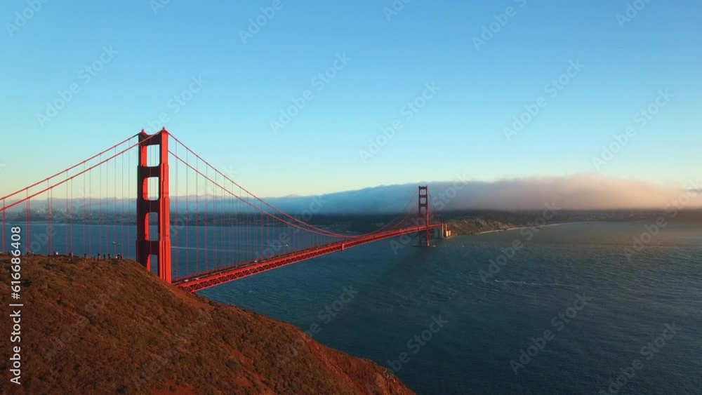 Aerial Shot Of Popular Golden Gate Bridge On Sea Near Mountains, Drone Flying Backward Over People Near Landmark Against Sky - San Francisco, California Aerial Shot Of Popular Golden Gate Bridge On Sea Near Mountains, Drone Flying Backward Over People Near Landmark Against Sky - San Francisco, California