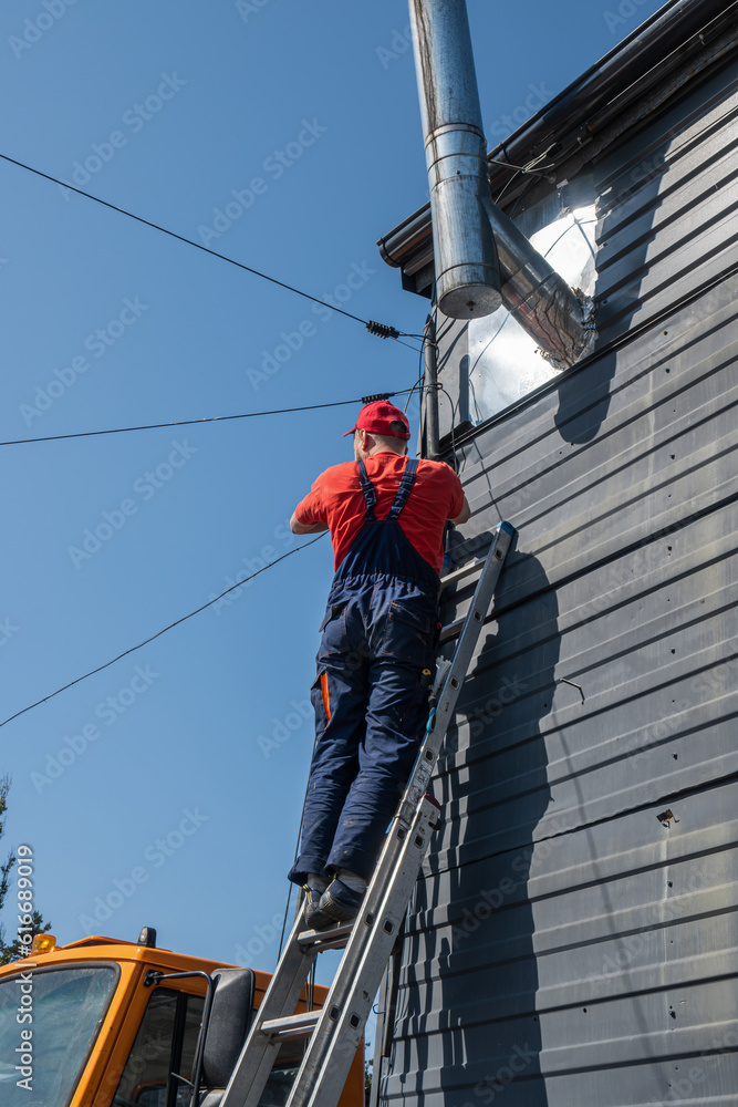 custom made wallpaper toronto digitalThe master climbs a high metal ladder for maintenance, modernization, repair, repair of electrical cable, optical fiber. professional male technician connects telecommunications network, electricity