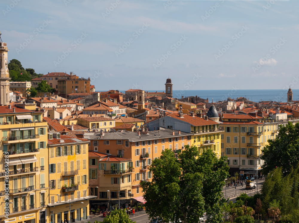 Aerial view of old Nice France cityscape rooftops with the  Mediterranean Sea in the background.