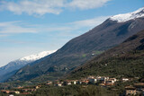 Picturesque Italian foothills with hotels and private houses located under the mountain against the background of the blue sky