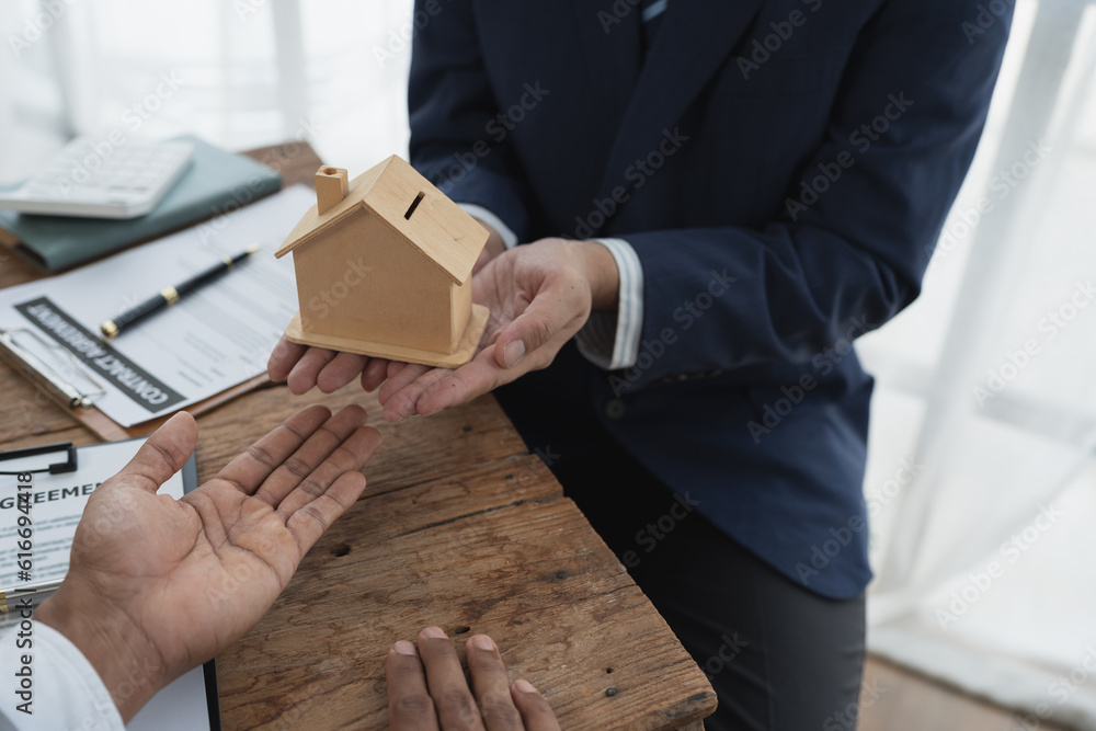 Real estate agents, insurance agents , The businessman delivers the model house or model house to the home buyer after signing the purchase contract, insurance in the office. Real estate agents, insurance agents , The businessman delivers the model house or model house to the home buyer after signing the purchase contract, insurance in the office.