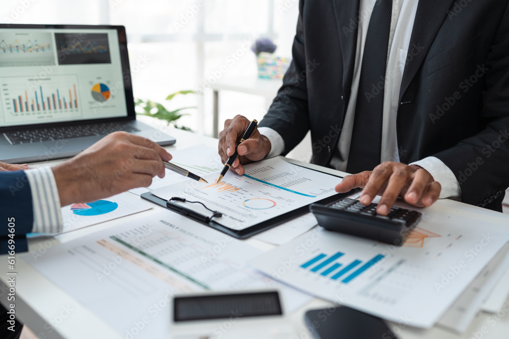 team work process Business team use calculator to calculate figures, business statistics, profit, cost analysis, growth rate graph document. data charts on the desk team work process Business team use calculator to calculate figures, business statistics, profit, cost analysis, growth rate graph document. data charts on the desk