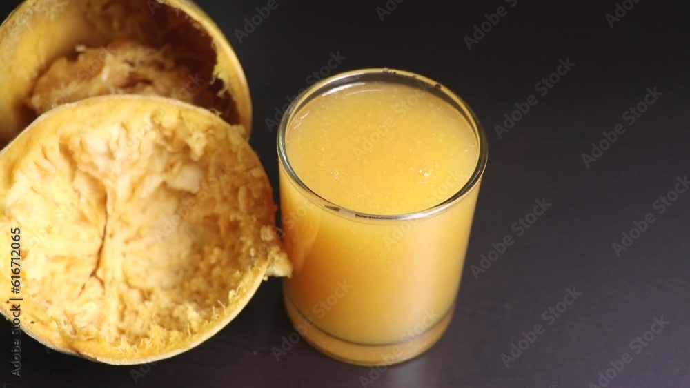 Juice of Bael also called as stone apple pouring into .Selective Focus