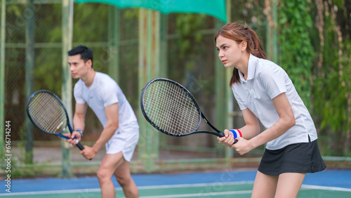 Two focused tennis player in activewear holding racket and aiming at opposite during game. © wattana