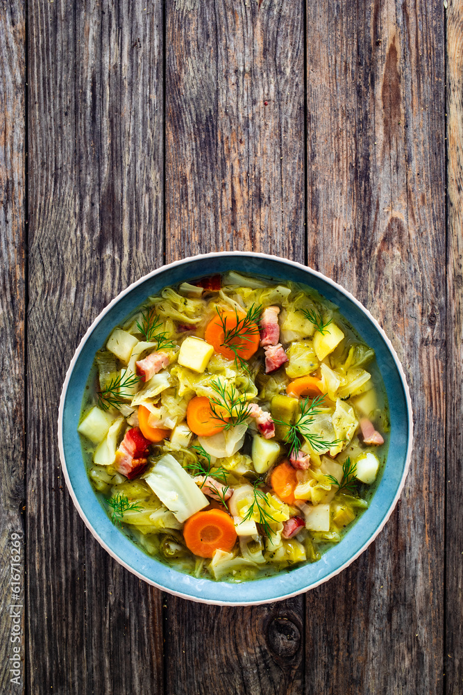Hot cabbage soup with bacon on wooden table
Hot cabbage soup with bacon on wooden table
