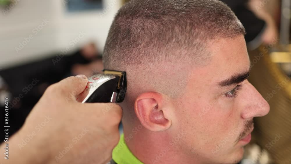 Side view of male client sitting in barber shop. Hair cut in salon Side view of male client sitting in barber shop. Hair cut in salon