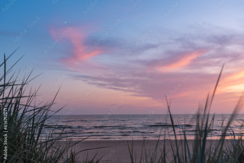 Summer evening after sunset on the Baltic sea beach with growing moon Summer evening after sunset on the Baltic sea beach with growing moon