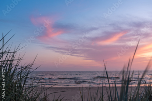 Summer evening after sunset on the Baltic sea beach with growing moon