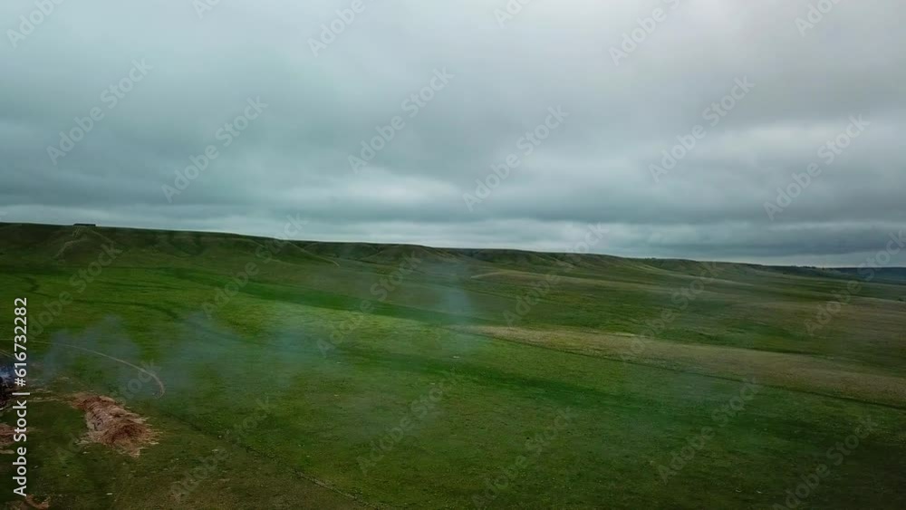 Aerial Panning Shot Of Motor Home Emitting Smoke On Green Plain, Drone Flying Over Landscape Against Cloudy Sky - Billings, Montana Aerial Panning Shot Of Motor Home Emitting Smoke On Green Plain, Drone Flying Over Landscape Against Cloudy Sky - Billings, Montana