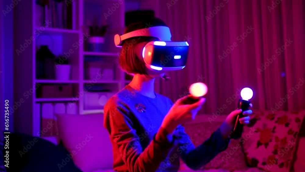 Pretty teenage girl wearing virtual reality headset in a dark room Pretty teenage girl wearing virtual reality headset in a dark room