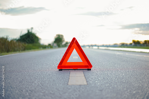 Close-up of red emergency stop sign placed on the road for vehicle accidents or breakdowns for road safety.