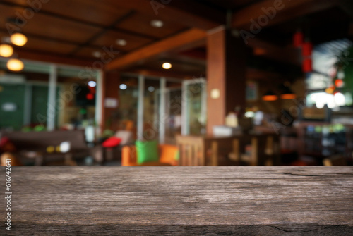 Empty dark wooden table in front of abstract blurred background of cafe and coffee shop interior. can be used for display or montage your products.