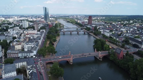 Zooming out of a section of the river Main flowing through Frankfurt, where the Floesser bridge, the Ignatz-Bubis bridge, and the old bridge can be seen. photo