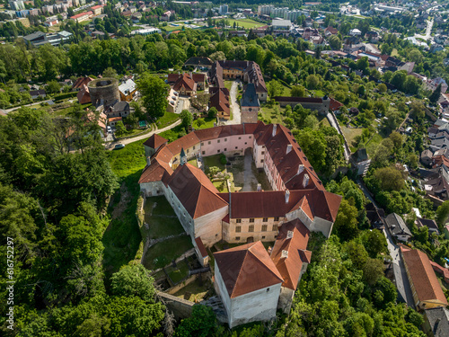 Aerial view of Vimperk Renaissance chateau castle with fortified round gun tower above the medieval town with blue sky