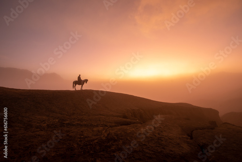 Beautiful sunrise scenery with silhouette horseman and his horse at Bromo Mountain  Bromo Tengger National Park