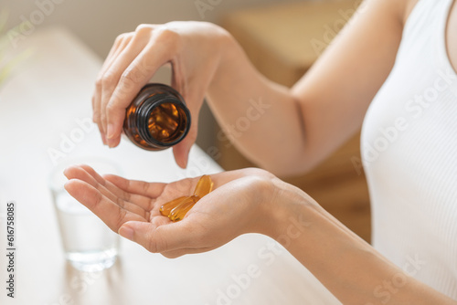 Dietary supplement or sick, asian young woman, girl hold pills, drugs medical tablet on hand pouring capsules from medication bottle, take vitamin for treatment for skin, hair at home, healthcare. photo
