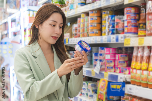 Foto Asian young woman, female in grocery, supermarket shopping food store hand holdi