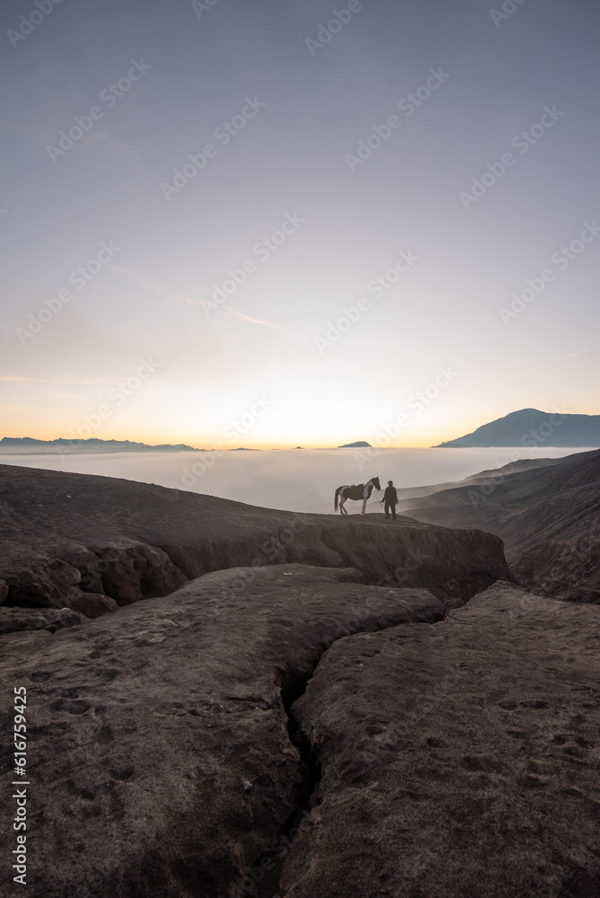 Beautiful sunrise scenery with silhouette horseman and his horse at Bromo Mountain, Bromo Tengger National Park Beautiful sunrise scenery with silhouette horseman and his horse at Bromo Mountain, Bromo Tengger National Park