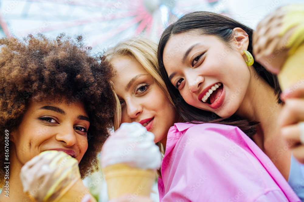 Multiracial young people together meeting at amusement park and eating ...