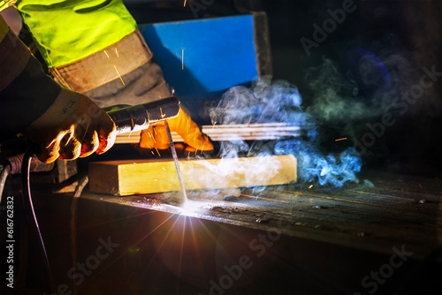 Welder is welding with shielded metal arc welding process to steel materials. Shielded metal arc (SMAW), also known as manual metal arc (MMA or MMAW), flux shielded arc welding.