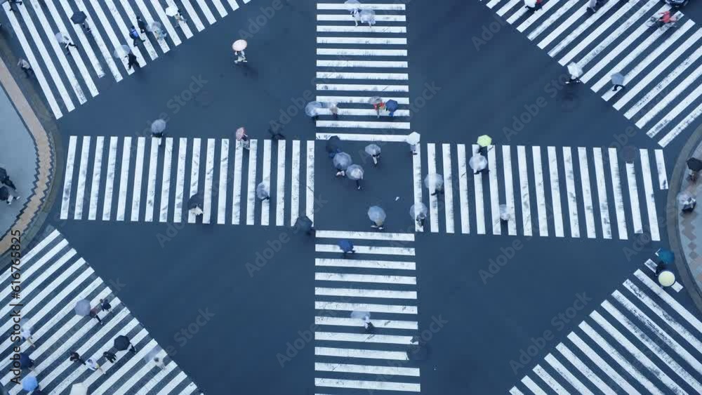 Aerial view of pedestrians walk crossing road intersection junction during a rainy day. Tokyo, Japan. Aerial view of pedestrians walk crossing road intersection junction during a rainy day. Tokyo, Japan.