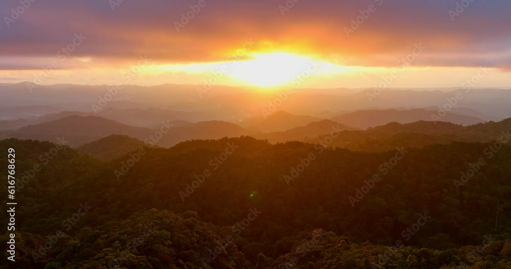 Aerial view The golden light penetrated the clouds on the mountain peak..Scene of Colorful romantic sky sunset with gold color of the sky background..4k resolution. golden light through the clouds. Aerial view The golden light penetrated the clouds on the mountain peak..Scene of Colorful romantic sky sunset with gold color of the sky background..4k resolution. golden light through the clouds.