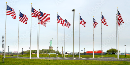 a view of Manhattan city skyline staue of liberty also visible from battery park , American flags in battery park, new jersey, USA 
