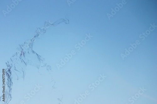 Soap bubbles on a blue sky illuminated abstract background with copy space 