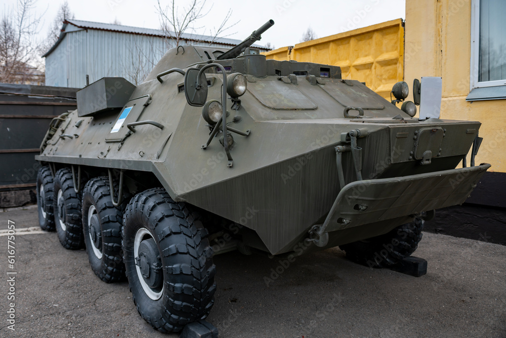 Green infantry fighting vehicle at a military base.